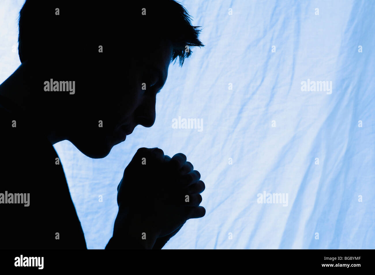 Silhouette of a man praying Stock Photo - Alamy
