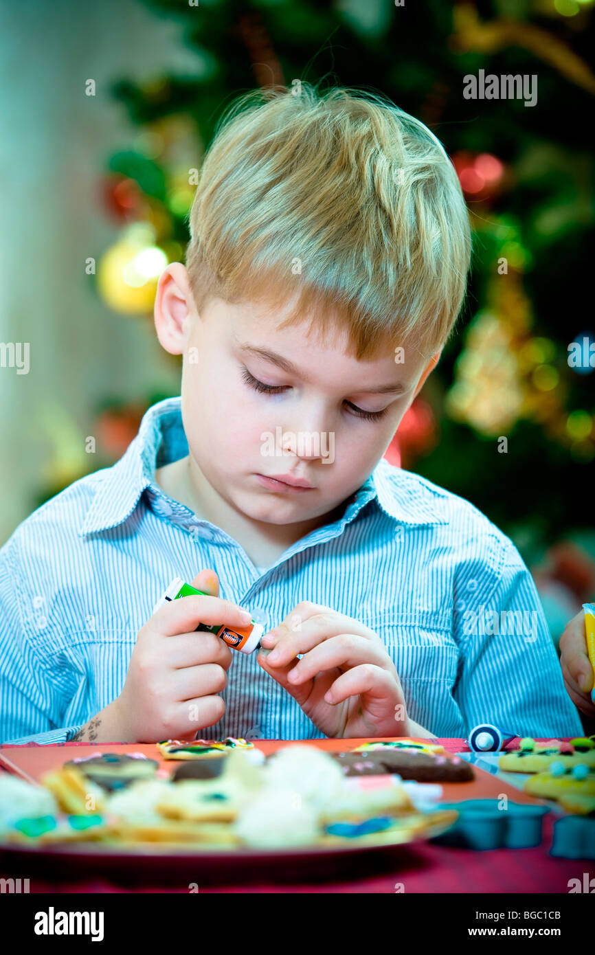 Christmas baking, 7-year-old boy decorating Christmas cookies Stock Photo