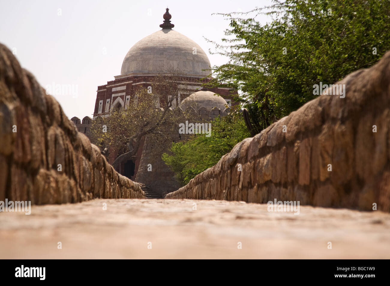 A walkway leads to the Mausoleum of Ghiyas-ud-Din Tughluq (Ghiyath-al-Din) at Tughluqabad in Delhi, India. Stock Photo