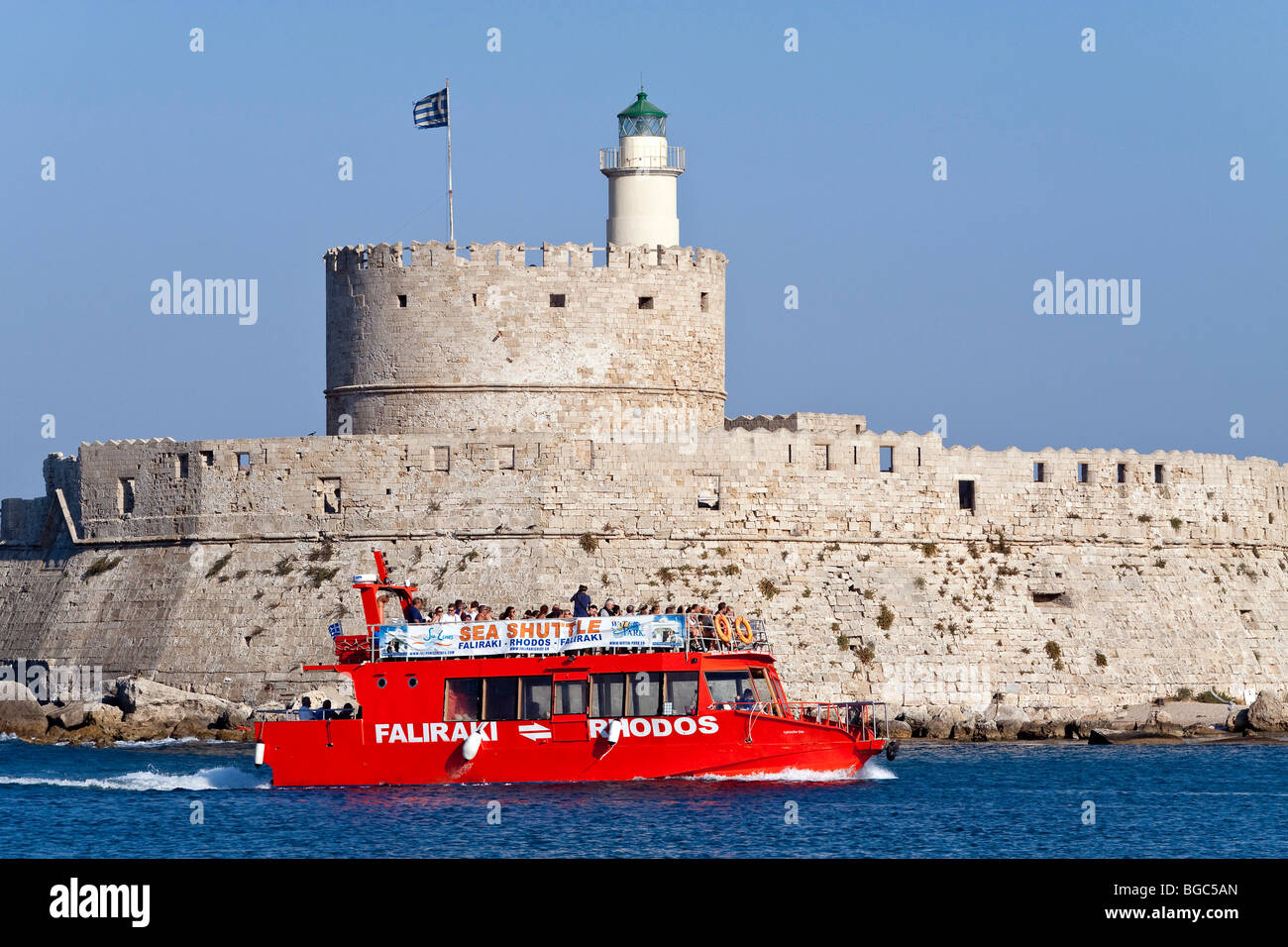 An excursion boat passes the harbor entrance, Rhodes town, Rhodes island, Greece, northern part, Aegean Sea, Southern Europe, E Stock Photo