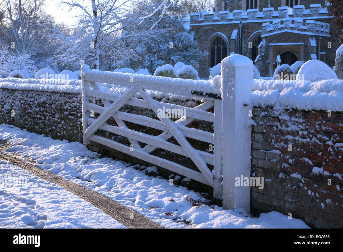 Snow covered wooden five-barred gate outside church Great Gransden Cambridgeshire Stock Photo
