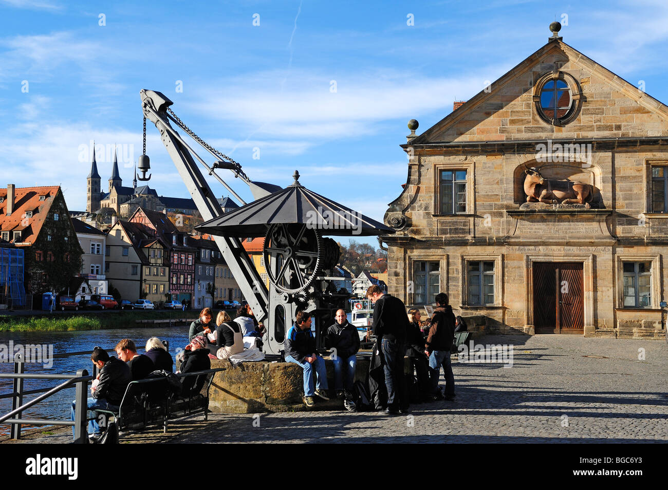 Old crane with students at the Regnitz river, on the right the old slaughter house, on the left 'little Venice', in the back St Stock Photo