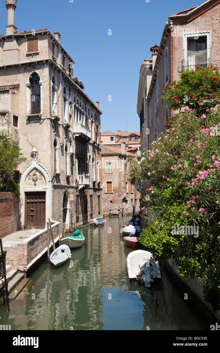 A Venice canal with boats showing traditional homes by the canal Stock Photo Alamy