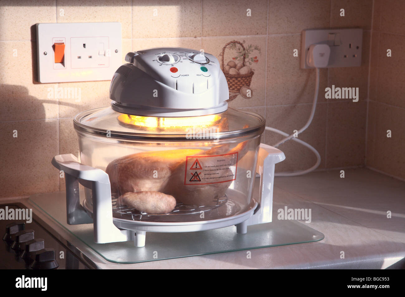 Chicken roasting in halogen oven Stock Photo - Alamy