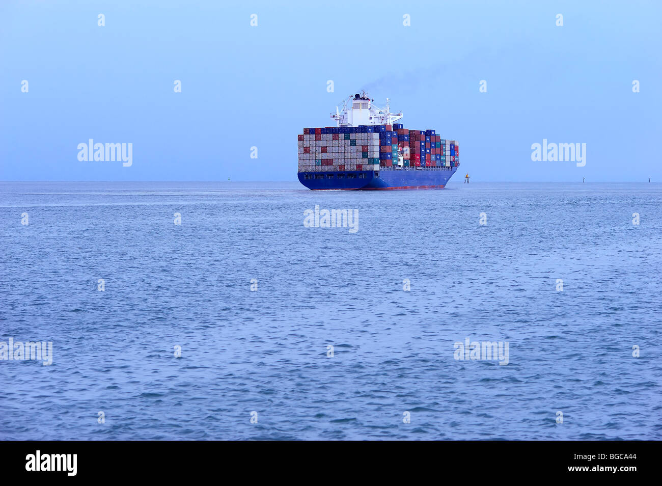 Container ship heading out to sea Stock Photo