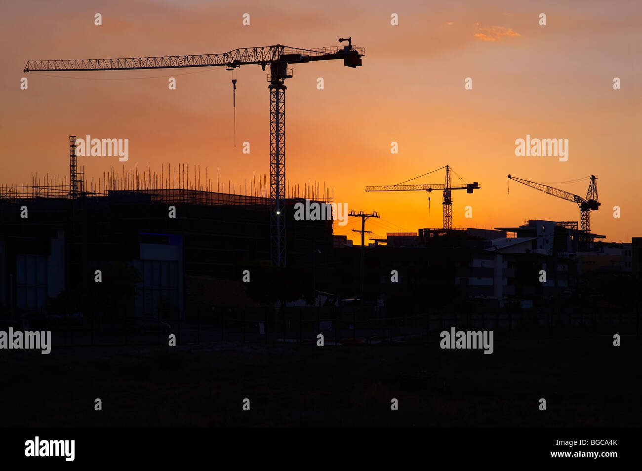 Tower cranes silhouetted on a construction site Stock Photo
