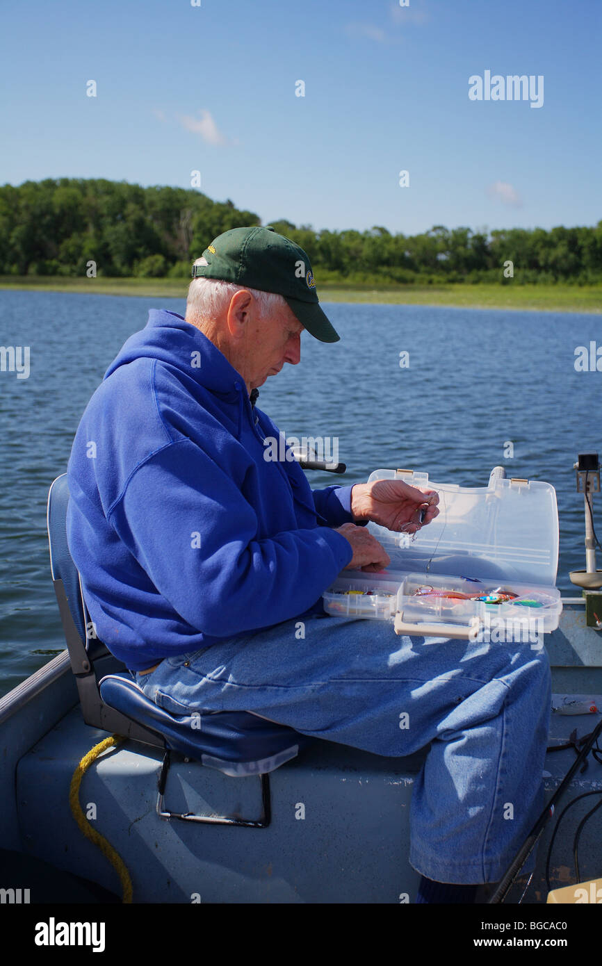 seasoned elderly senior fishing guide fishing in alumnacraft boat Stock Photo
