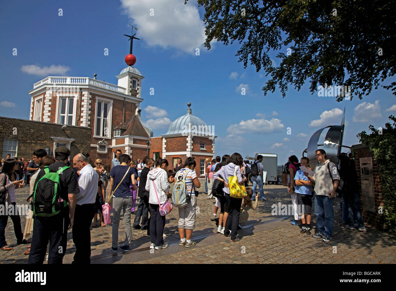 Tourists standing on the Prime Meridian line at the Royal Observatory, Greenwich, London, England Stock Photo