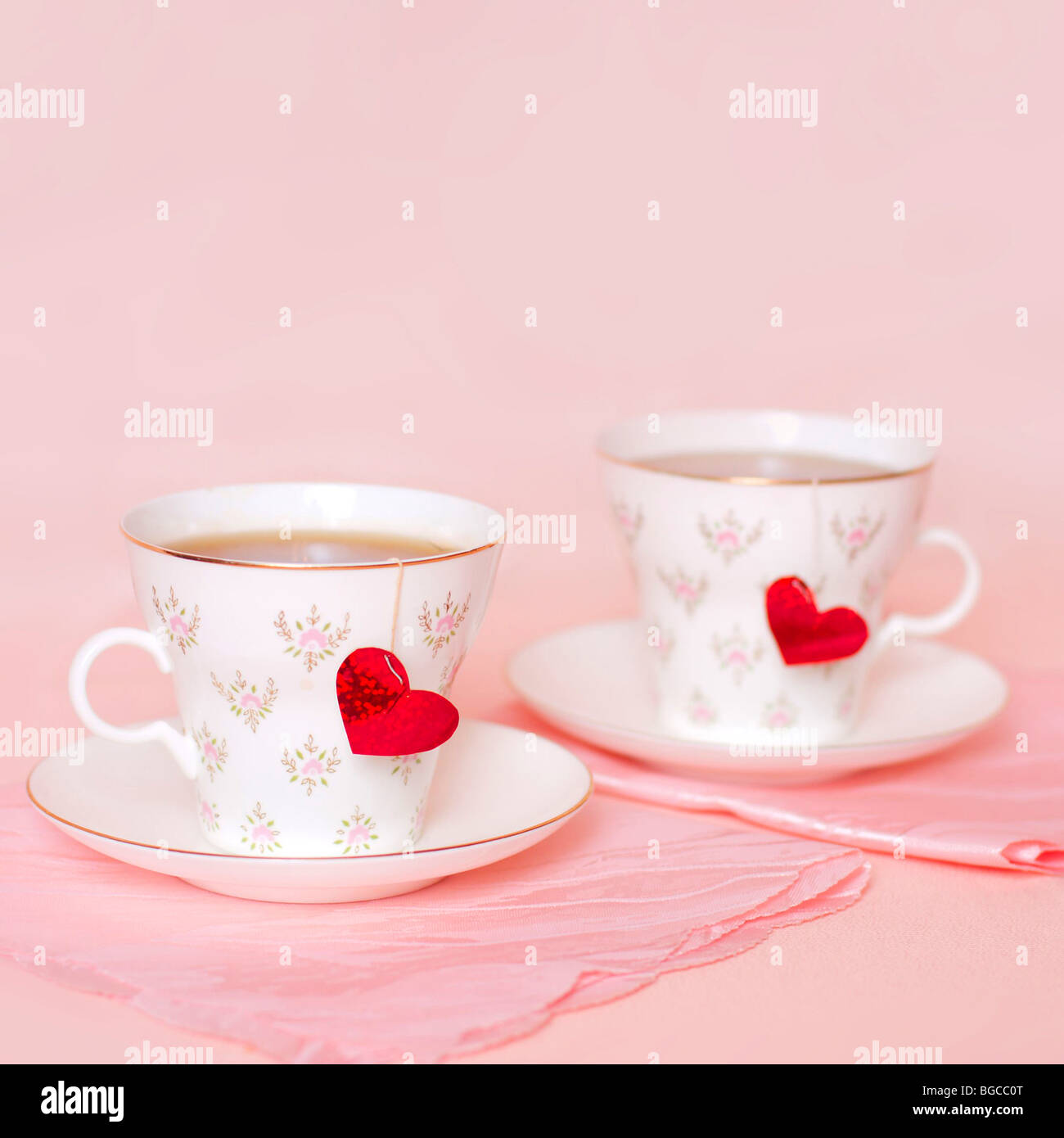 two cups with hearts on the pink background Stock Photo