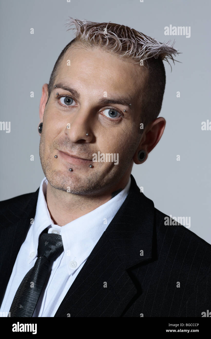 studio shot of isolated picture of a strange caucasian businessman with piercing and tattoo Stock Photo