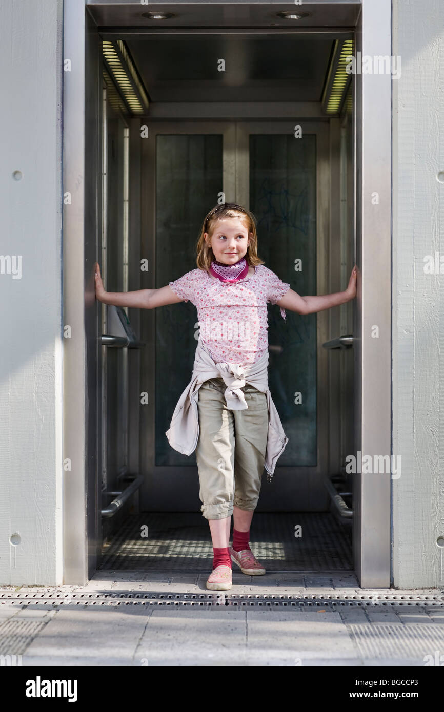 Girl standing in open elevator Stock Photo