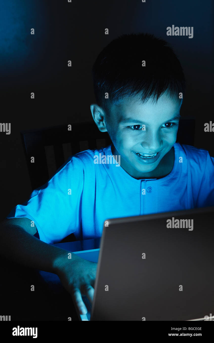 Young Asian boy with laptop at night Stock Photo - Alamy