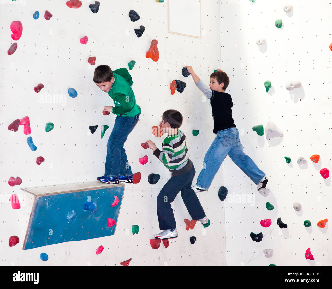 Children practice climbing on indoor climbing wall Cardiff Wales UK