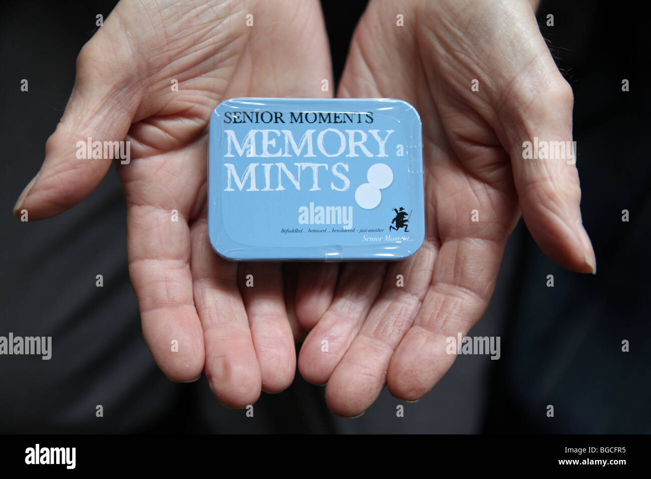 An  elderly male holds a tin of memory mints Stock Photo