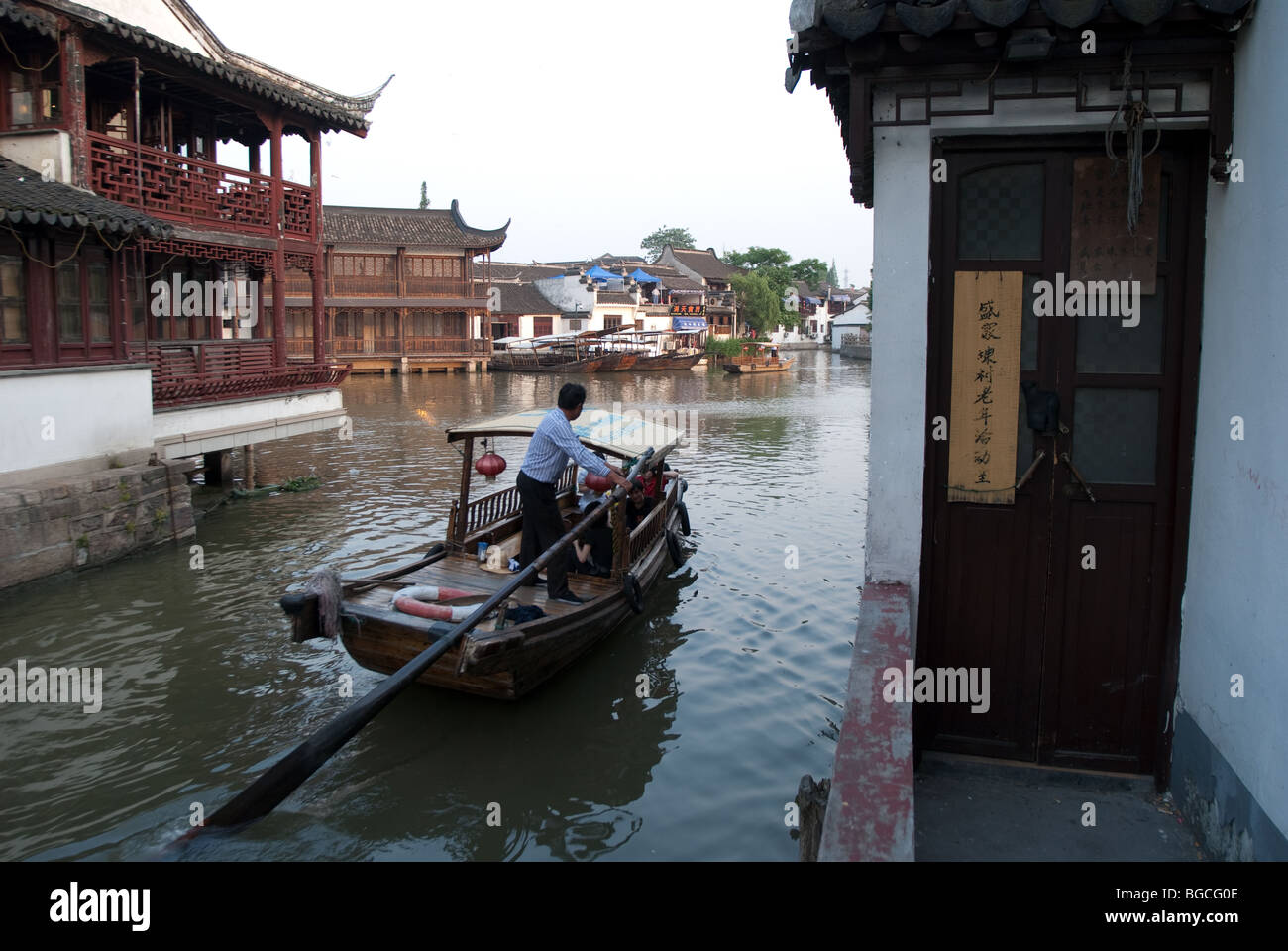 A boatman rows in the canal looking for tourists, Zhujiajiao, China Stock Photo