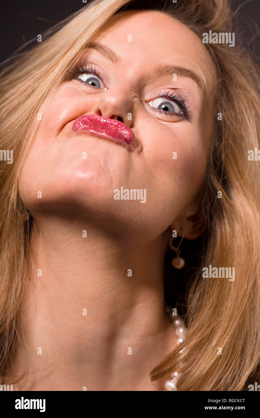 Glamorous blonde woman pulling a silly face Stock Photo