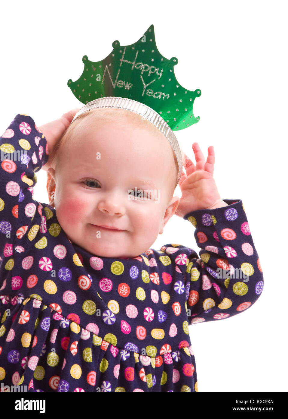 1 year old little girl tries Happy New Year paper crown isolated on