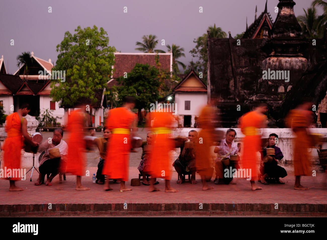 Laos; Luang Prabang; Monks collecting alms at dawn Stock Photo