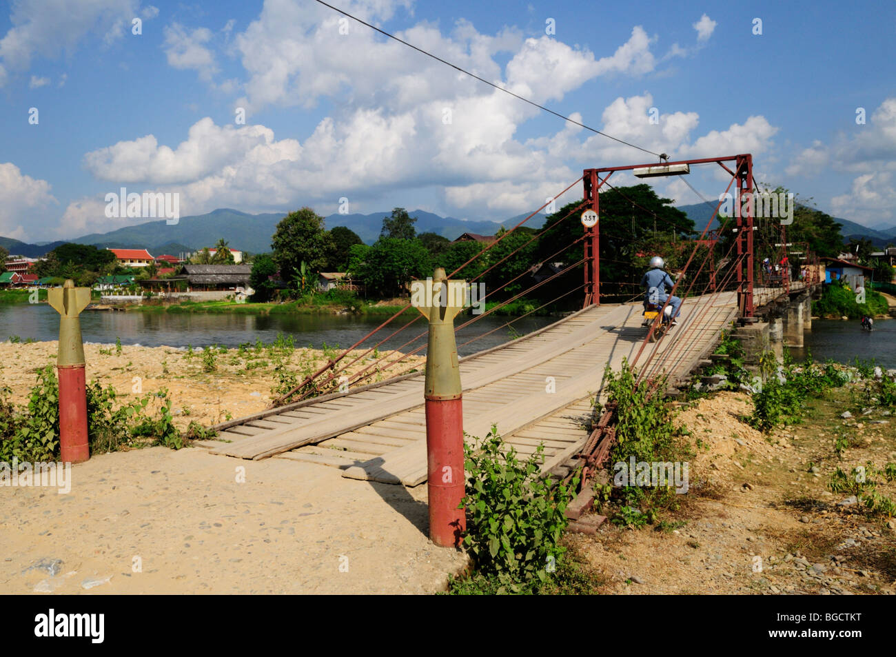 Laos; Vang Vieng; Bridge over the Nam Song River with bomb casings marking the start of the bridge Stock Photo