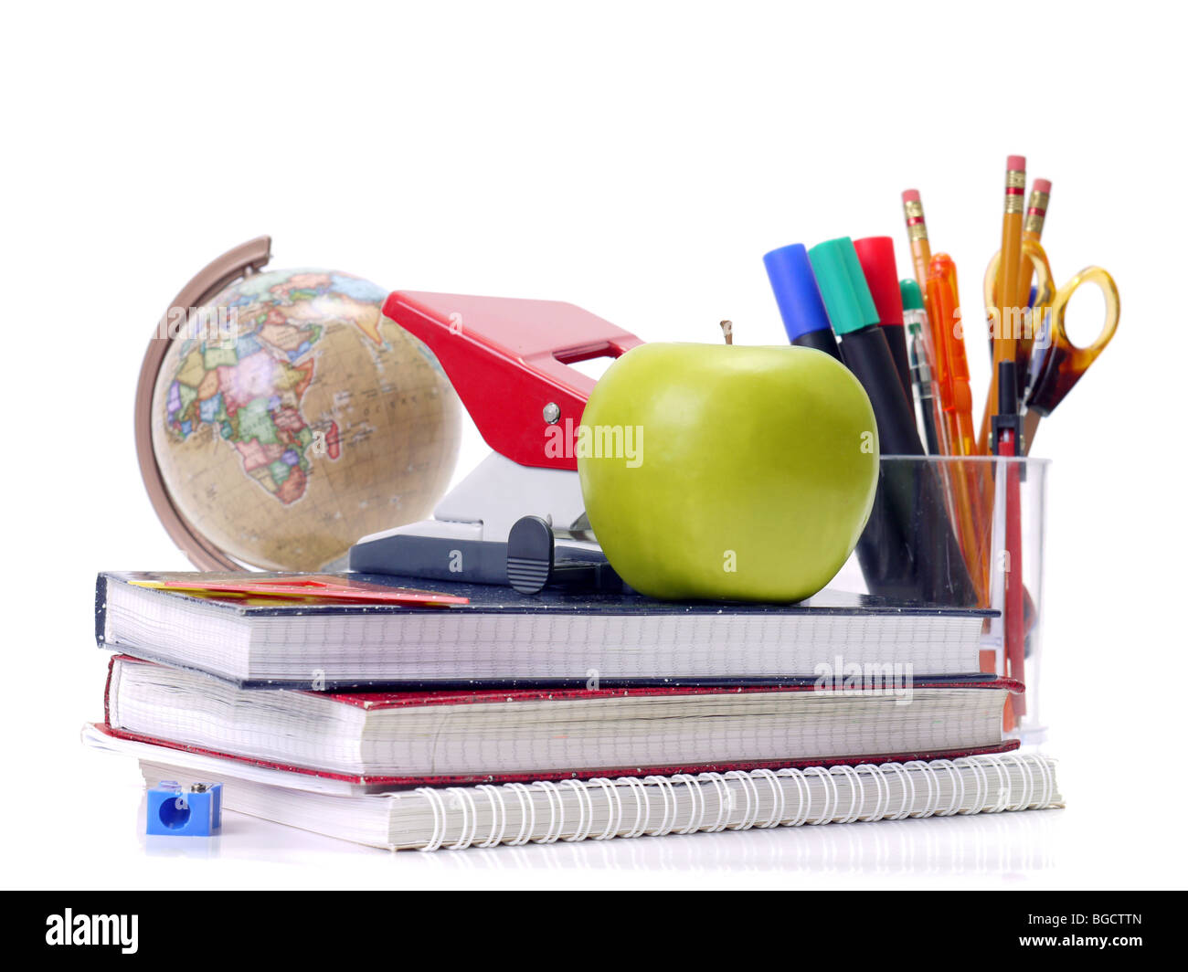 Assorted school aids and green apple shot over white background Stock Photo