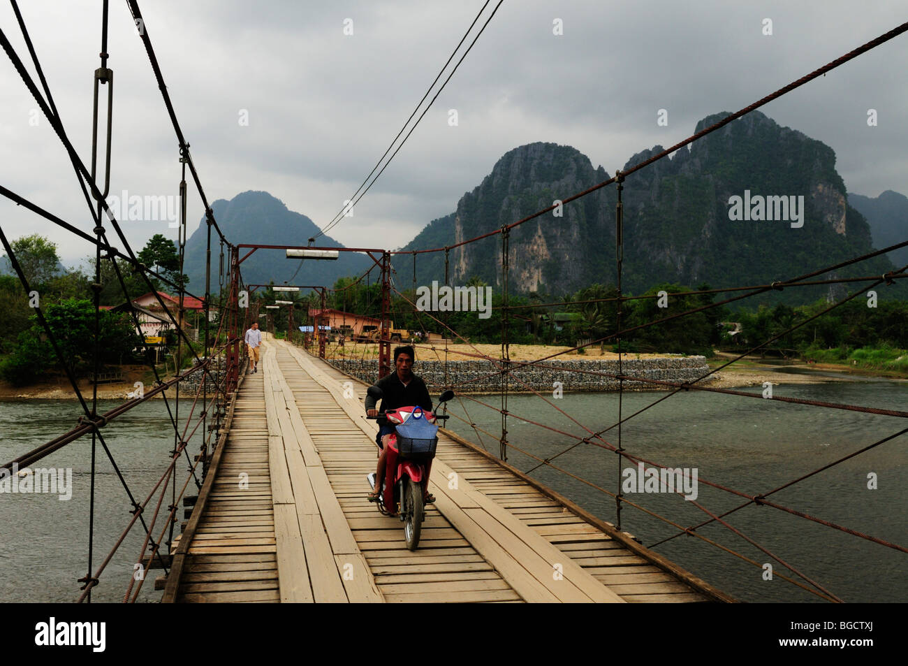 Laos; Vang Vieng; Mororcycle crossing on the bridge over the Nam Song River Stock Photo