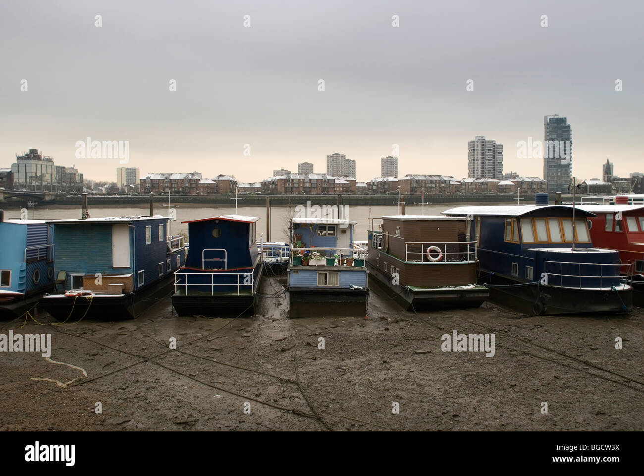 Houseboats lined up and sitting on the river bed alongside Chelsea