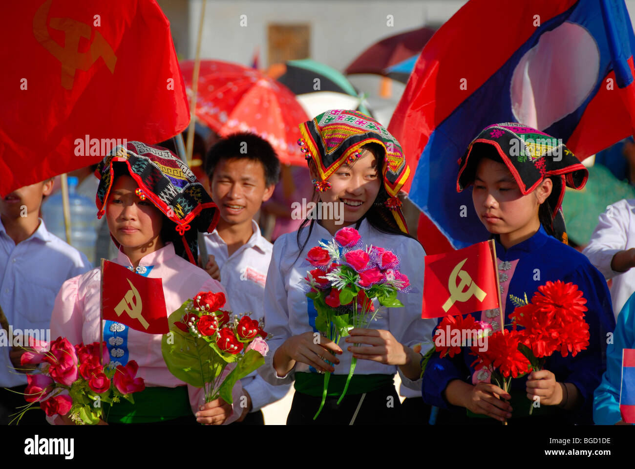 Festival, Tai Dam girls, dressed in traditional clothing, holding red flags of the Communist Party, national flag of Laos, Xam  Stock Photo