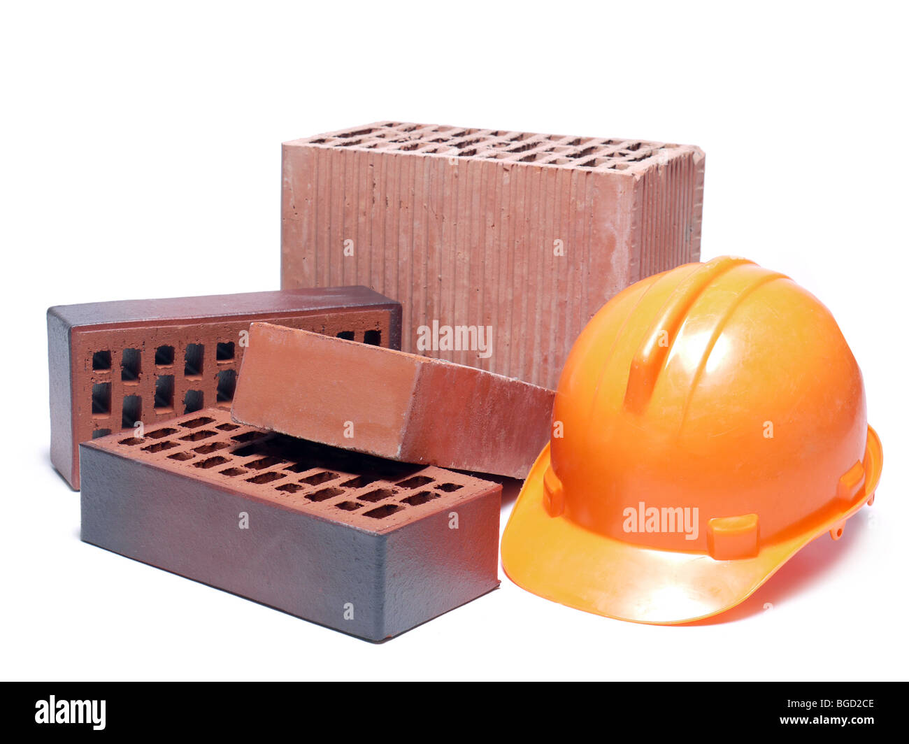Solid and perforated bricks and orange hard hat isolated on white Stock Photo