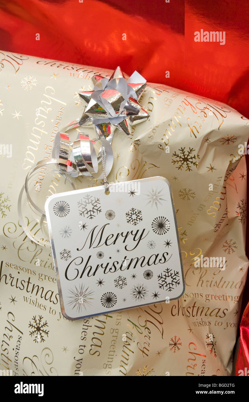 Silver Bow Ribbon and A Merry Xmas Label On Christmas Wrapping Paper Stock Photo