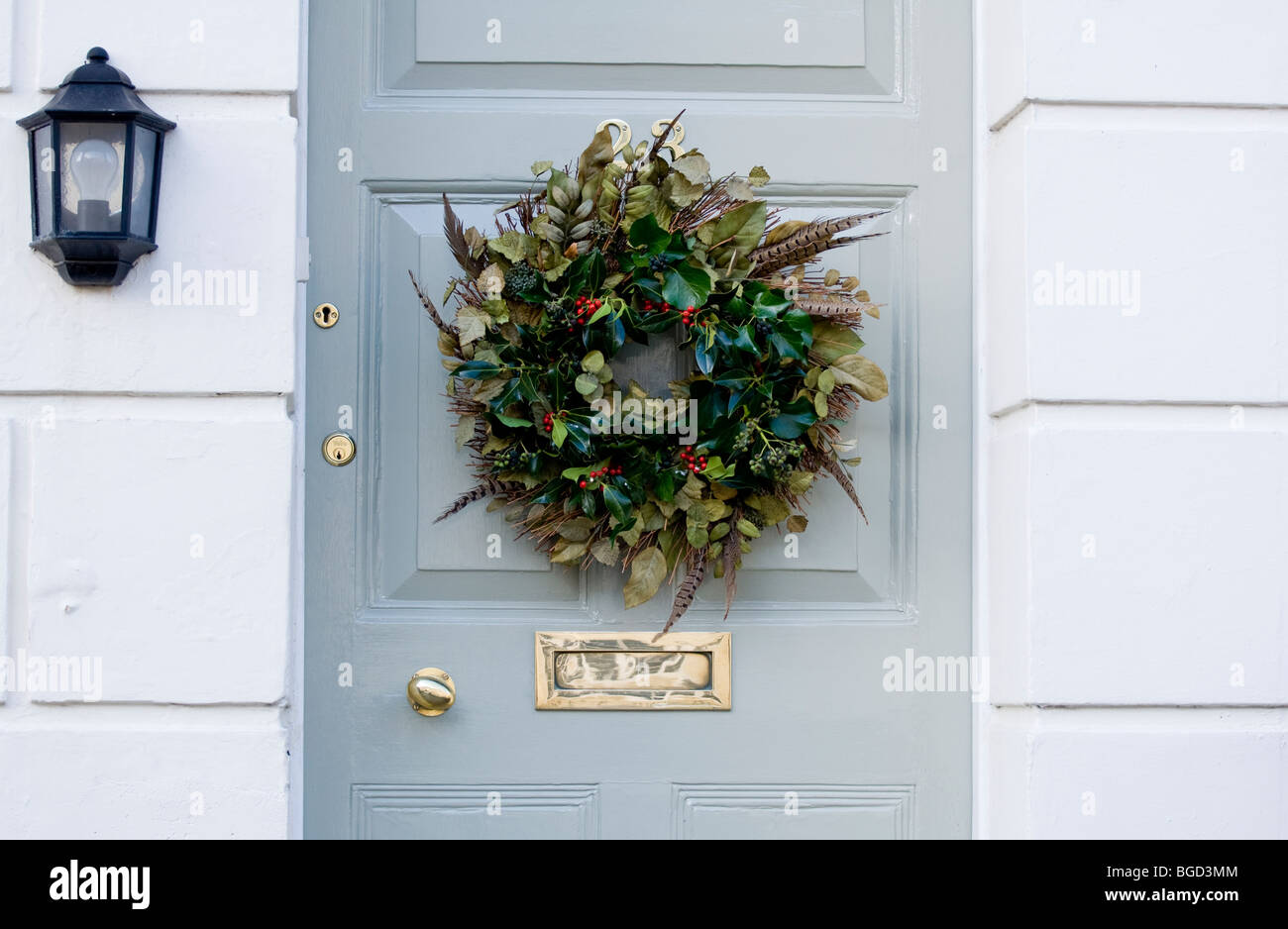 Stylish Regency home, with elegant Christmas Wreath with holly and pheasant feathers. Stock Photo
