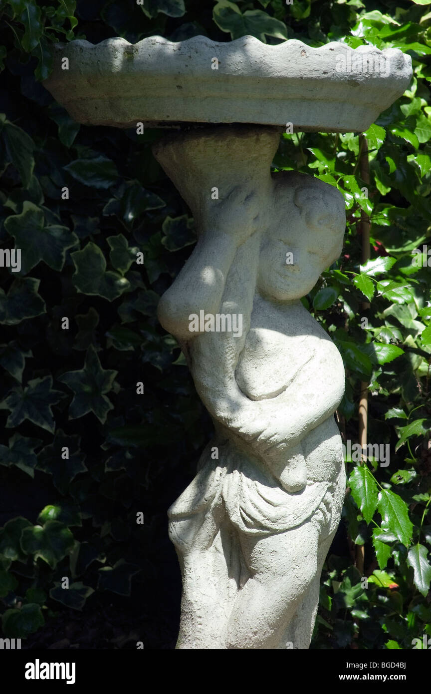 Bird bath sitting on top of a nymph in an English garden Stock Photo