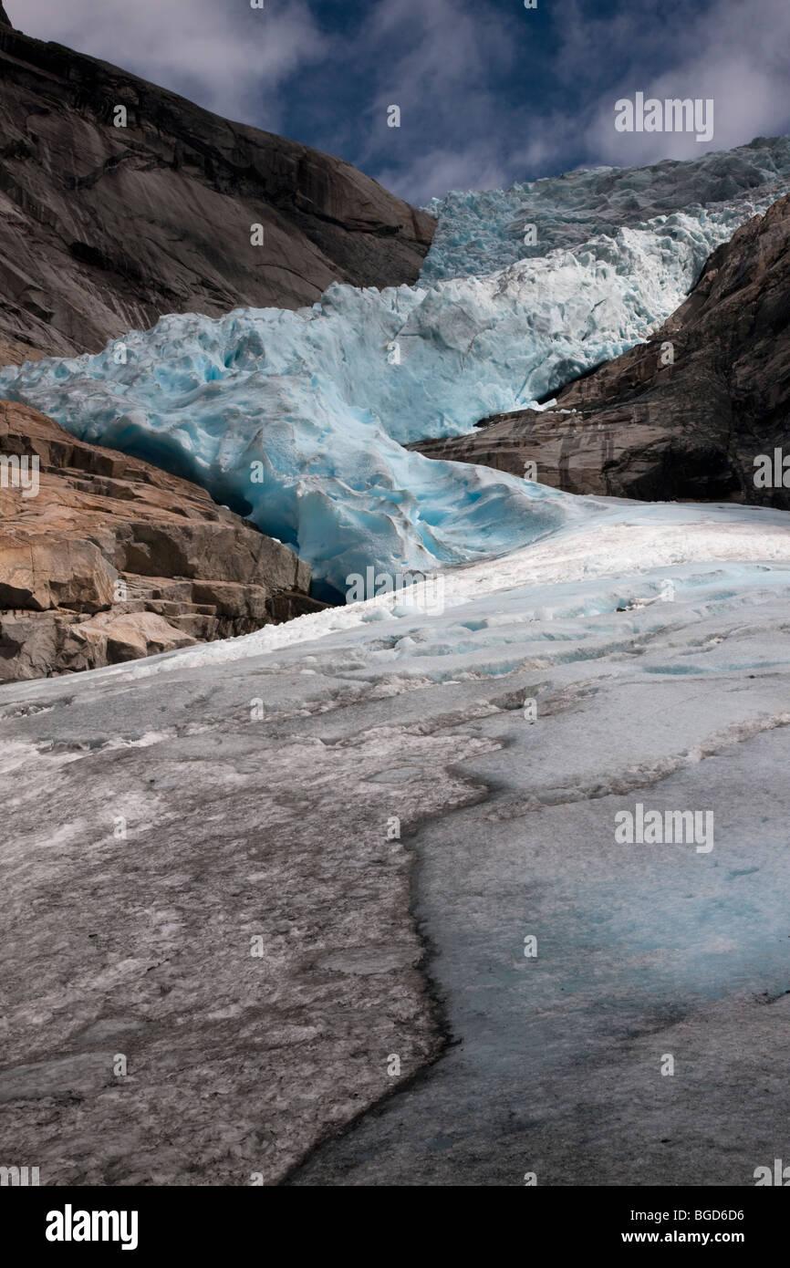 Dramatic wide angle close up summer portrait of tall shrinking Briksdal Glacier, Loen Norway, blue sky wispy white clouds background WOP Stock Photo
