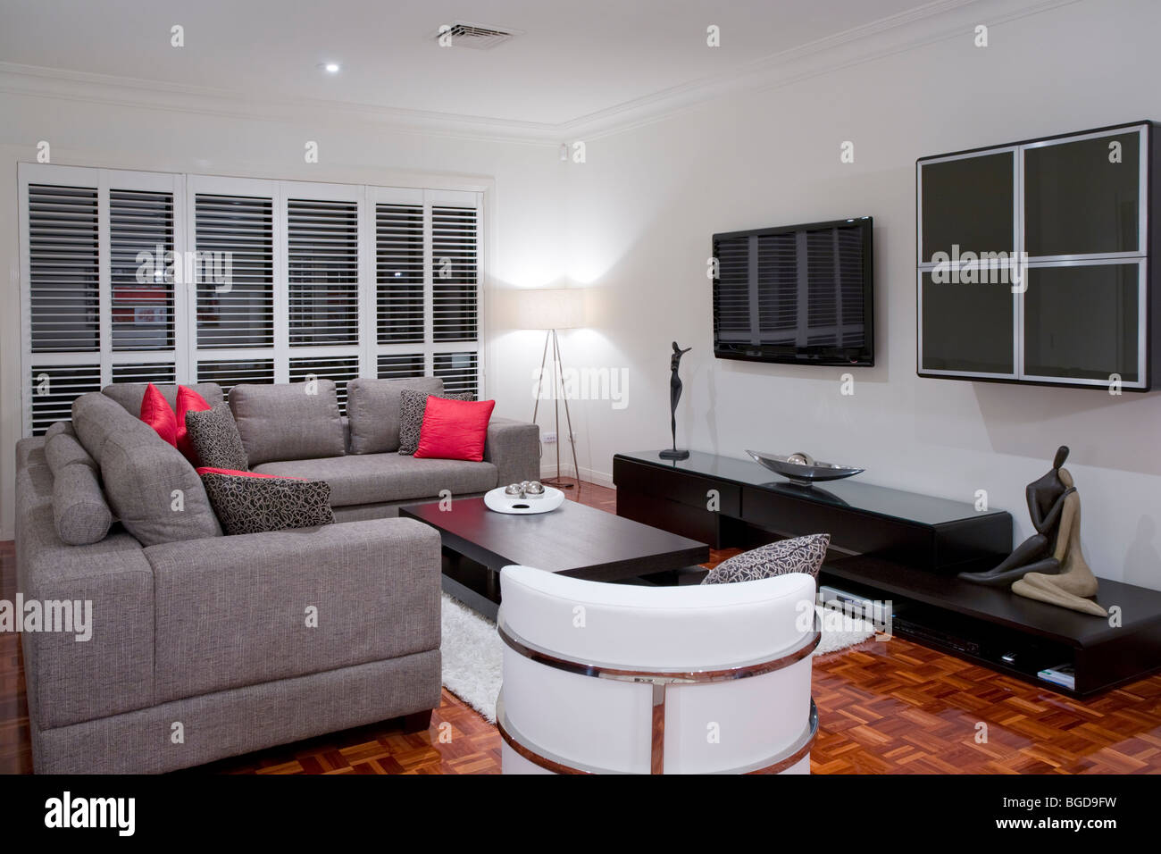 modern living room interior with charcoal sofa and chocolate brown coffee table and wide screen plasma TV. Stock Photo