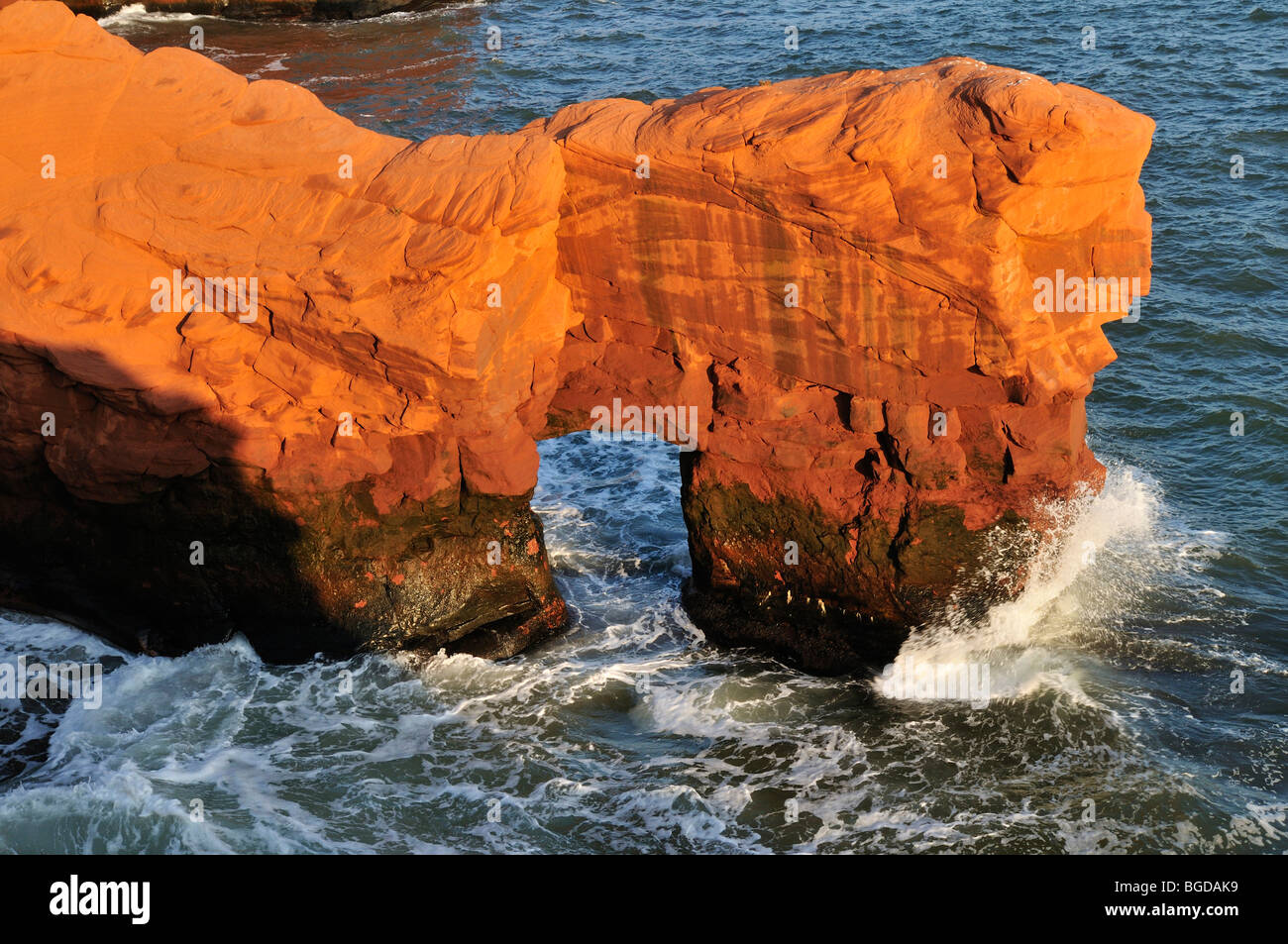 Red cliffs with natural arch at Cap du Phare, Ile du Cap aux Meules, Iles de la Madeleine, Magdalen Islands, Quebec Maritime, C Stock Photo