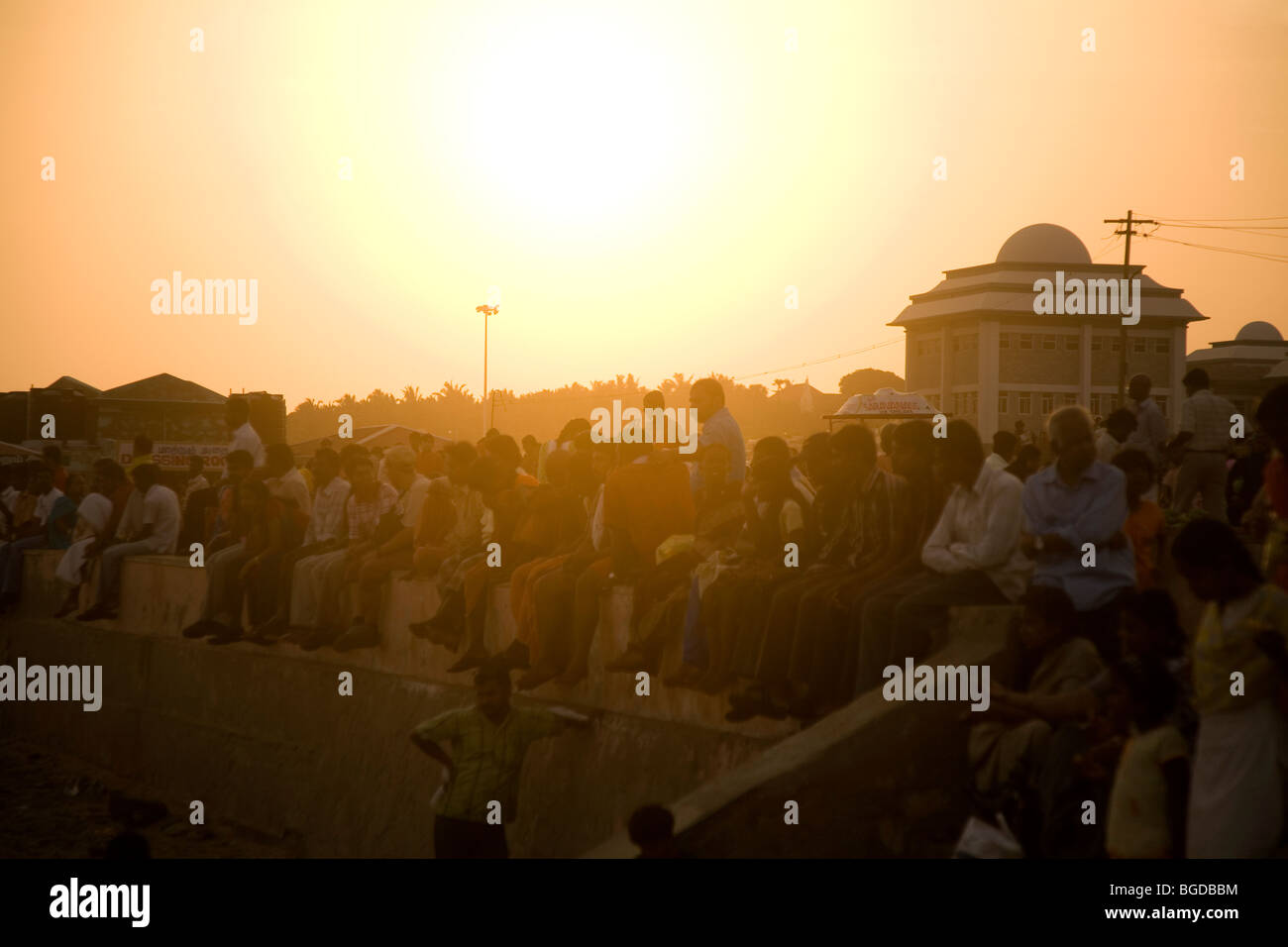 People gather to enjoy the late glow of the afternoon sun and sunset at Kanyakumari (Cape Cormorin) in India. Stock Photo