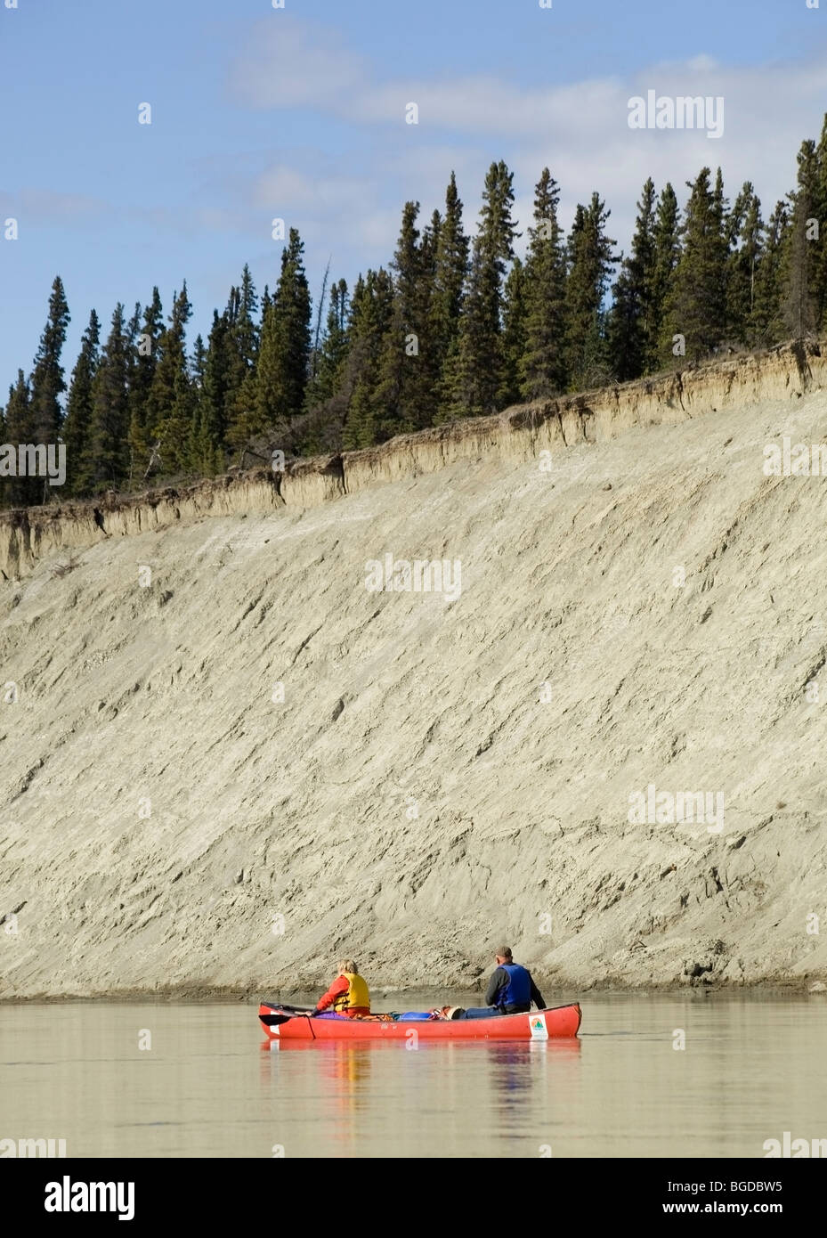 Couple, man and woman in a canoe, canoeing, high cut bank, erosion behind, Takhini River, Yukon Territory, Canada Stock Photo