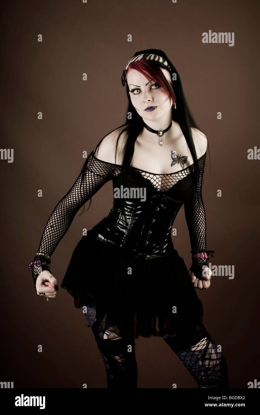 Woman, Gothic style, standing with a serious expression and clenched fists Stock Photo