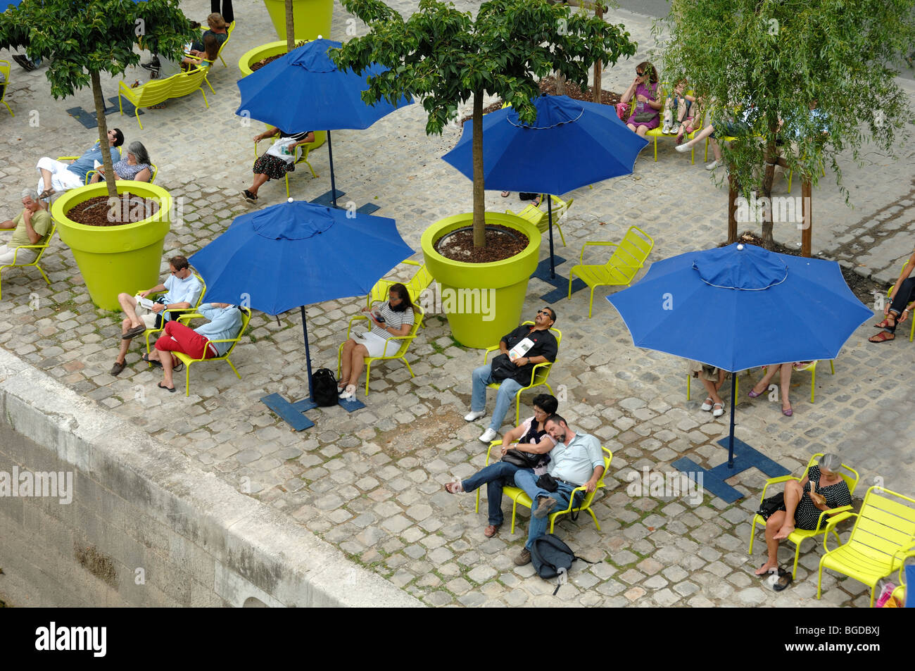 Tourists People Relaxing, Blue Parasols & Deckchairs Along Quai of the River Seine during 'Paris-Plage' Events, Quai de l'Hôtel de Ville, Paris France Stock Photo