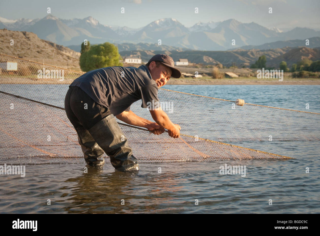 Local fisherman mending the fishing net. Karakol, Kyrgyzstan Stock