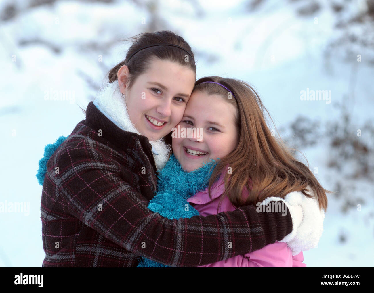 Sisters happily hugging out in cold weather Stock Photo