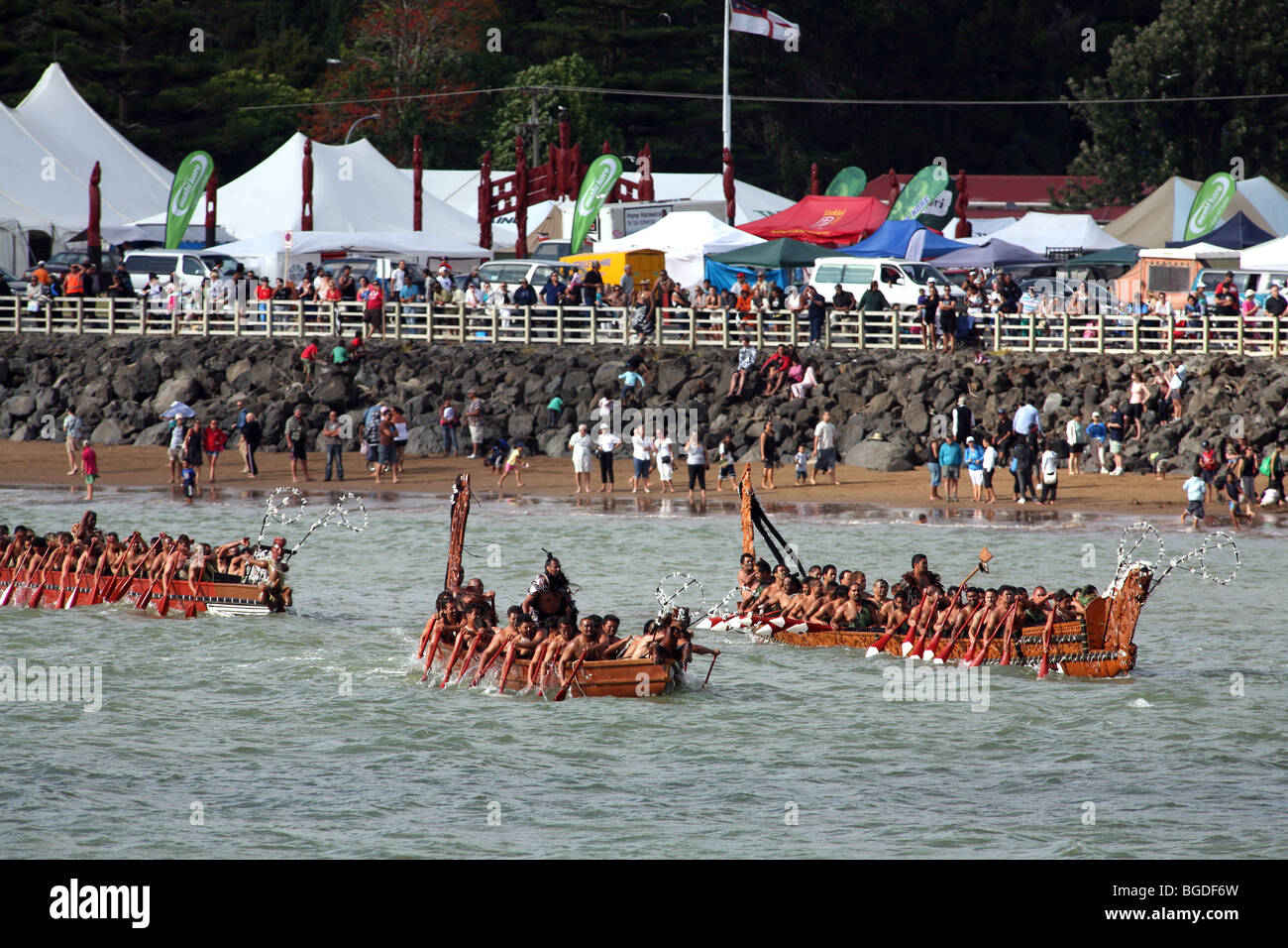 Waka Taua (war canoes) paddling past spectators on Te Ti Bay during Waitangi Day celebrations, New Zealand Stock Photo