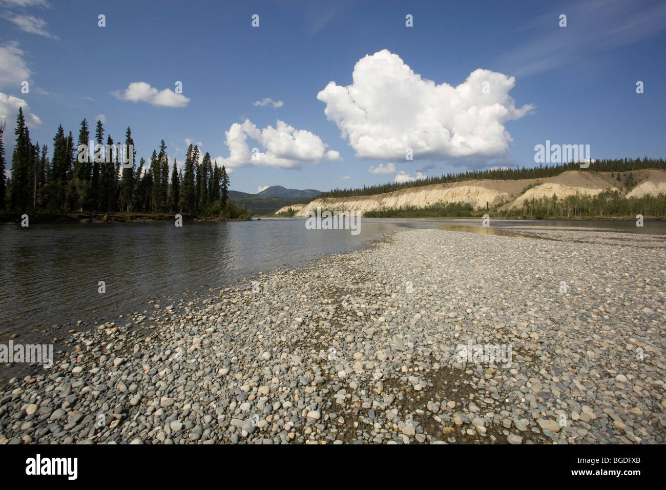 Gravel bar on Teslin River, water formed landscape, high cut bank, erosion behind, Yukon Territory, Canada Stock Photo