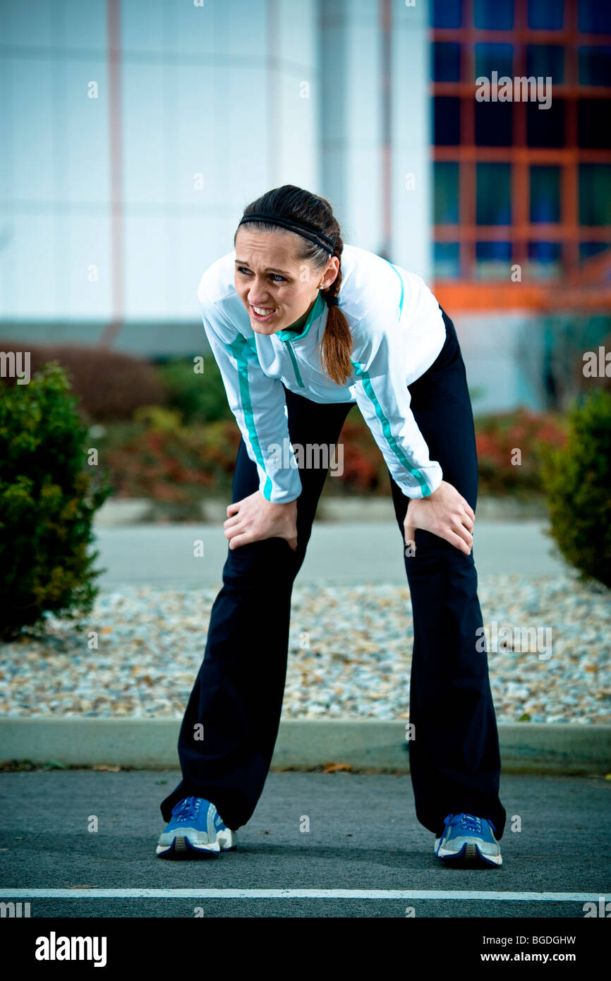 Young woman taking a break while jogging Stock Photo