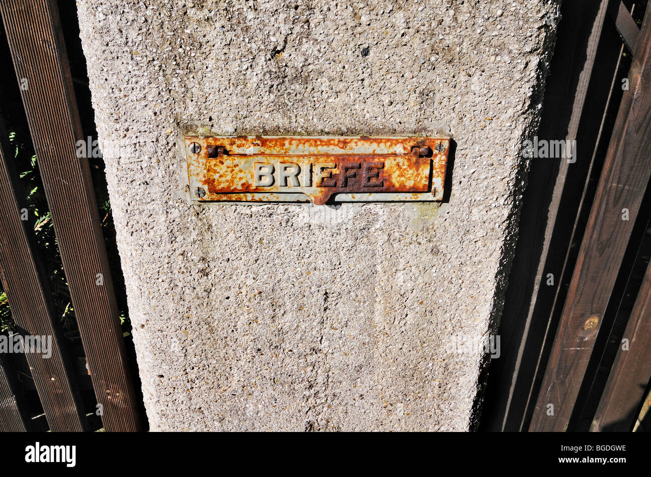 Rusted mail slot at a garden fence Stock Photo