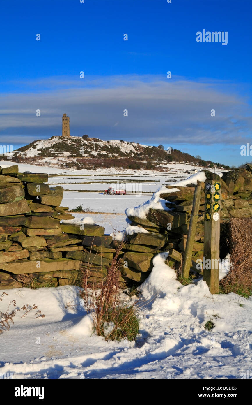 Tractor and trailer in snow covered fields below Jubilee Tower, Castle Hill, Huddersfield, West Yorkshire, England, UK. Stock Photo