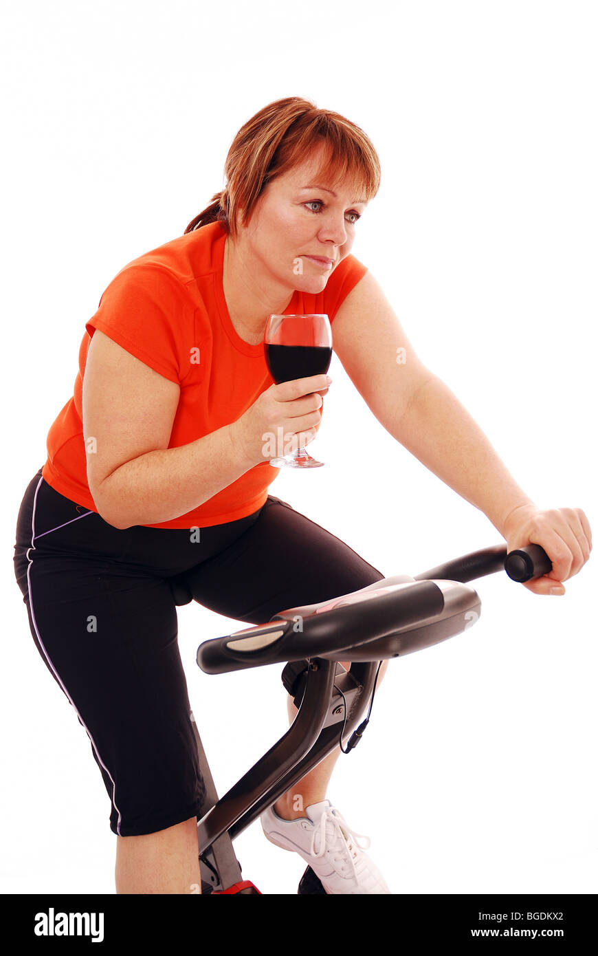 Woman on exercise bike drinking wine Stock Photo Alamy