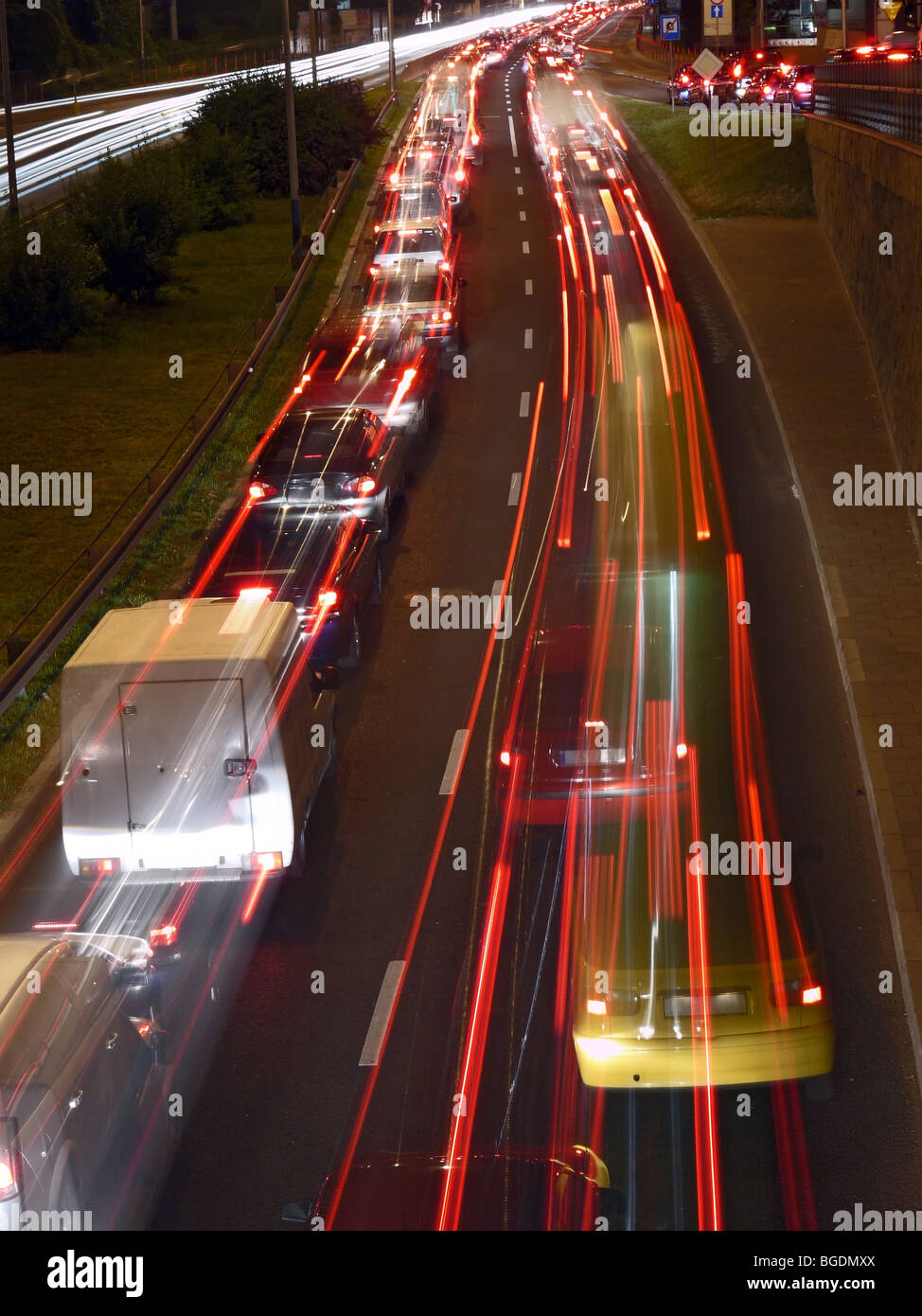Night traffic light trails created by red rear and white headlights of vehicles moving on two-way motorway - long exposure Stock Photo