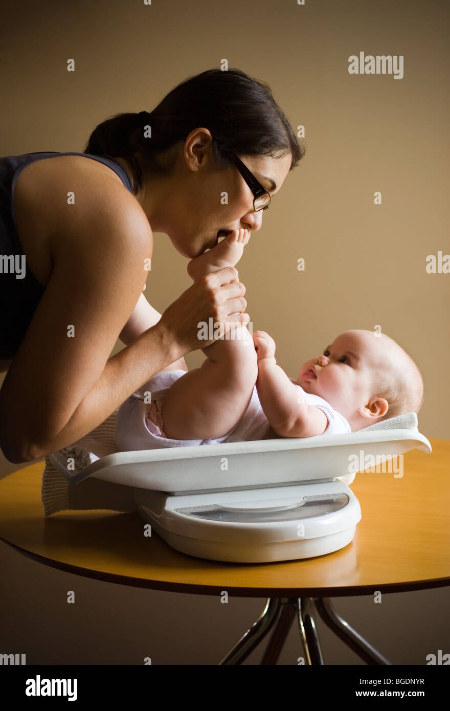 Mother weighing baby Stock Photo