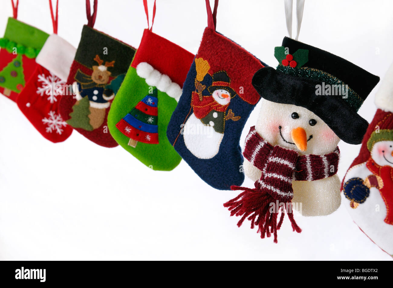 Collection of Christmas stockings with snowmen hanging on white background Stock Photo