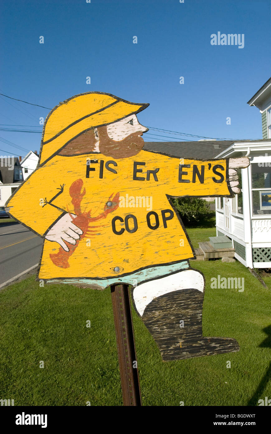 A sign with missing letters and leg giving directions to a fisherman's coop in Port Clyde Maine